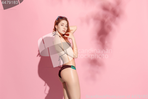 Image of Beautiful female model posing on pink background