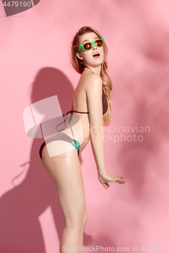 Image of Beautiful female model posing on pink background