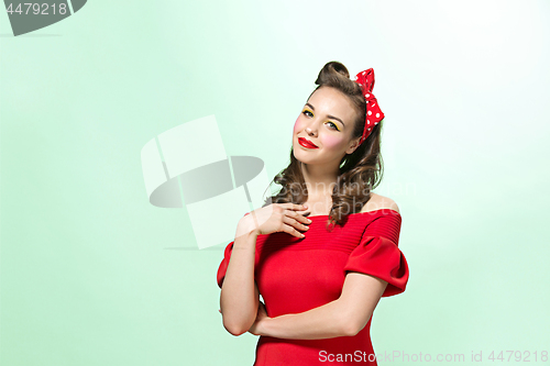 Image of Beautiful young woman with pinup make-up and hairstyle. Studio shot on white background