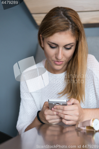 Image of young woman using mobile phone