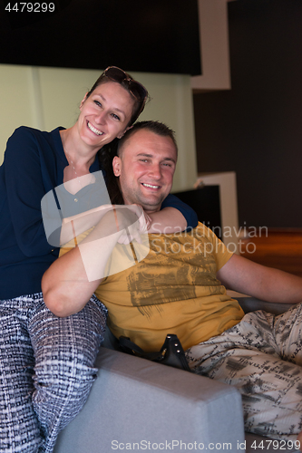 Image of young handsome couple hugging on the sofa