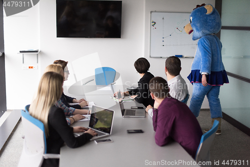 Image of boss dresed as bear having fun with business people in trendy of