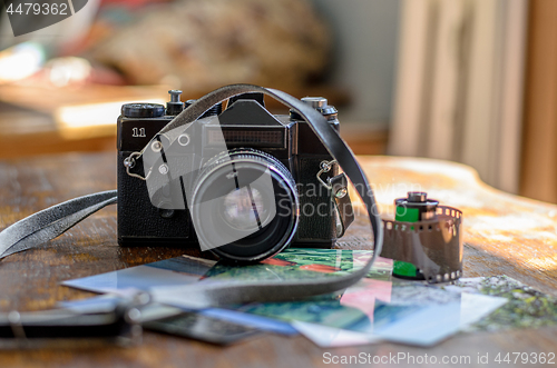 Image of Old photo film roll and retro camera on desk.