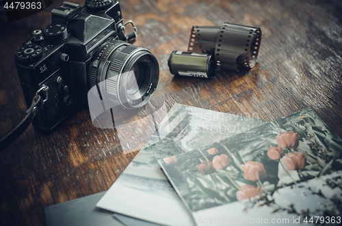 Image of Retro photo camera, film and old photos on the table