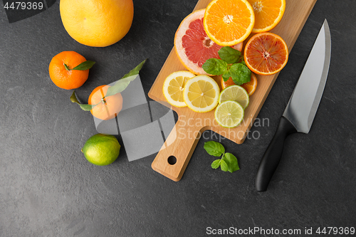 Image of close up of fruits and knife on slate table top