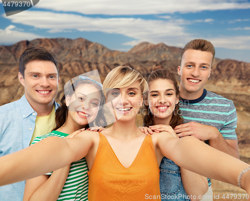 Image of happy friends taking selfie over grand canyon