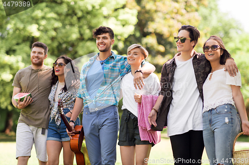 Image of friends with guitar and picnic blanket at park