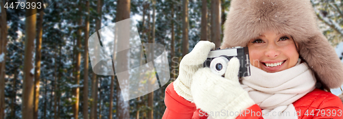 Image of happy woman with film camera over winter forest