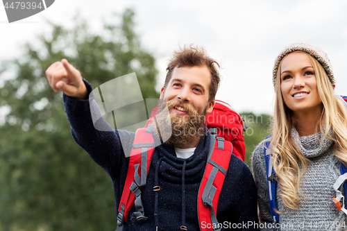 Image of couple of travelers with backpacks hiking