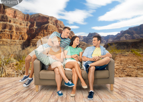 Image of friends sitting on sofa over grand canyon