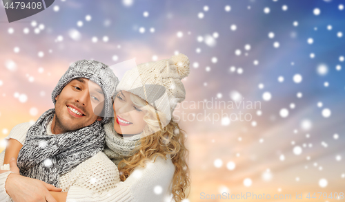 Image of smiling couple in sweaters over snow background