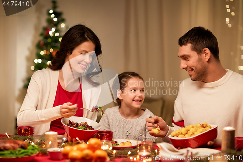 Image of happy family having christmas dinner at home