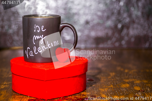 Image of Valentine's day concept with black cup, chalk inscription on a mug and a red heart