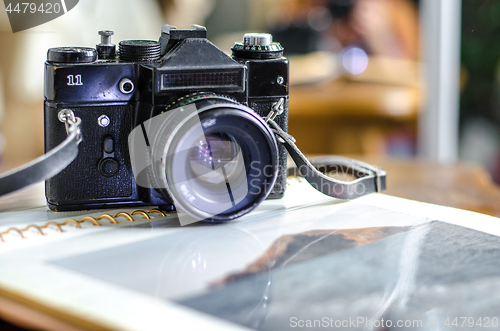 Image of Retro photo camera, film and old photo album on the table