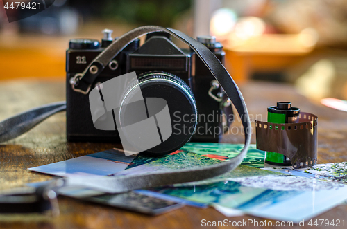 Image of Old photo film roll and retro camera on desk.