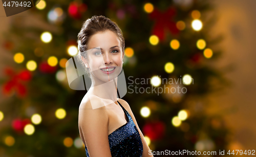 Image of beautiful woman over christmas tree lights