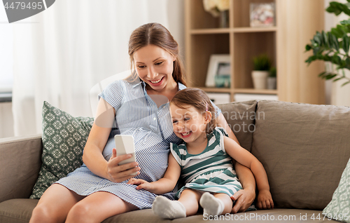 Image of pregnant mother and daughter with smartphone