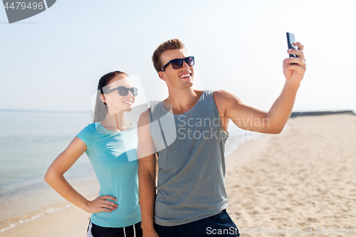 Image of couple taking selfie by smartphone on beach