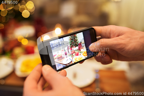 Image of hands photographing food at christmas dinner