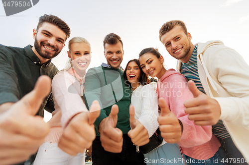 Image of happy friends showing thumbs up