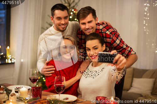 Image of friends taking selfie at christmas dinner