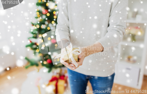 Image of close up of man with christmas gift at home