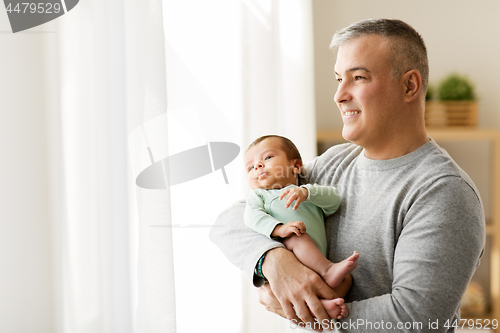 Image of happy father holding with little baby son at home