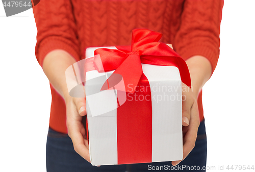 Image of close up of woman in red sweater holding gift box