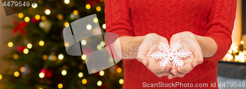 Image of close up of woman holding snowflake on christmas