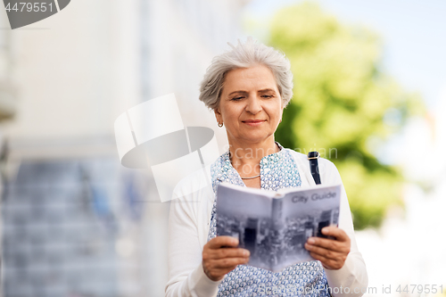 Image of senior woman or tourist with city guide outdoors