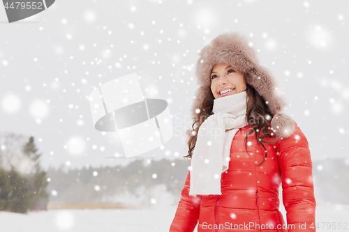 Image of happy woman in winter fur hat outdoors