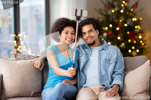 Image of couple with smartphone taking selfie on christmas