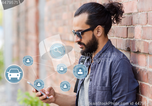 Image of man using smartphone car sharing app on street