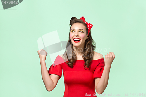 Image of Beautiful young woman with pinup make-up and hairstyle. Studio shot on white background