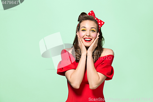 Image of Beautiful young woman with pinup make-up and hairstyle. Studio shot on white background