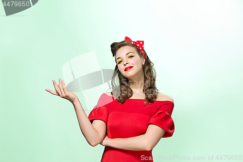 Image of Beautiful young woman with pinup make-up and hairstyle. Studio shot on white background