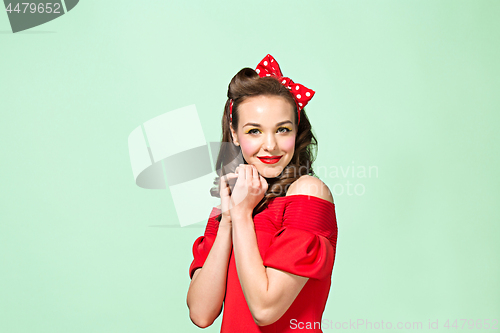 Image of Beautiful young woman with pinup make-up and hairstyle. Studio shot on white background