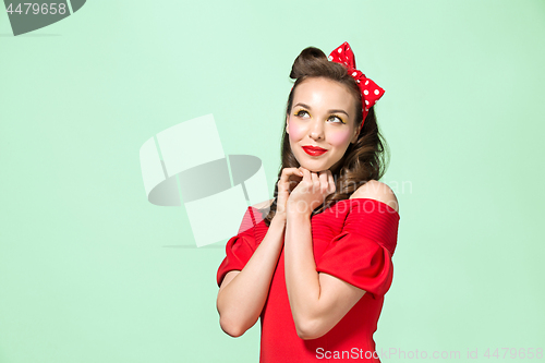 Image of Beautiful young woman with pinup make-up and hairstyle. Studio shot on white background