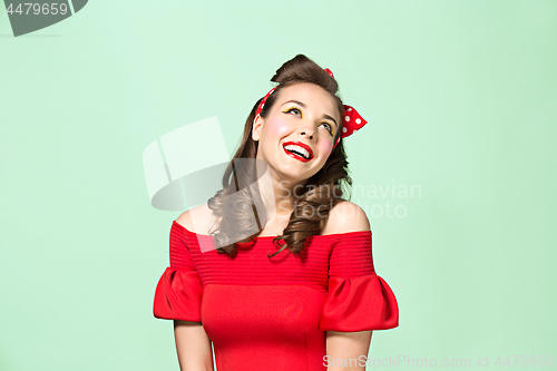 Image of Beautiful young woman with pinup make-up and hairstyle. Studio shot on white background