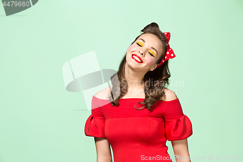 Image of Beautiful young woman with pinup make-up and hairstyle. Studio shot on white background