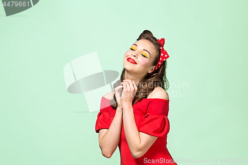 Image of Beautiful young woman with pinup make-up and hairstyle. Studio shot on white background