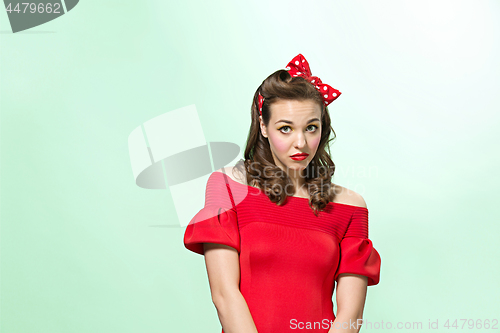 Image of Beautiful young woman with pinup make-up and hairstyle. Studio shot on white background