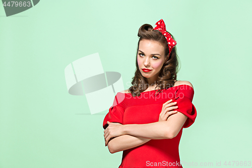 Image of Beautiful young woman with pinup make-up and hairstyle. Studio shot on white background