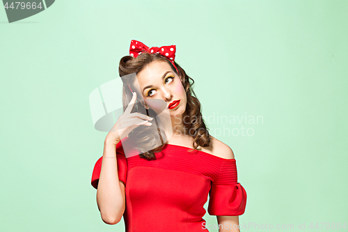 Image of Beautiful young woman with pinup make-up and hairstyle. Studio shot on white background