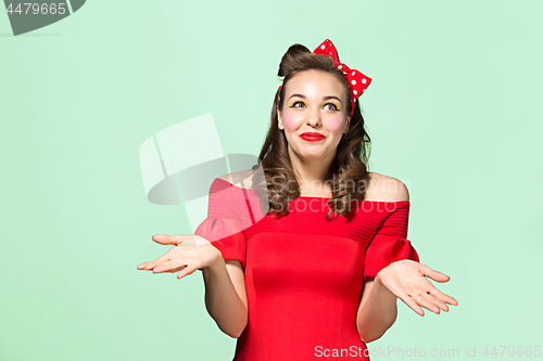 Image of Beautiful young woman with pinup make-up and hairstyle. Studio shot on white background