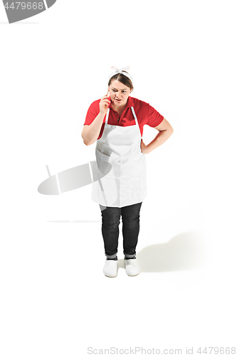 Image of Portrait of cute serious woman with mobile phone in her hands in the studio, isolated on white background