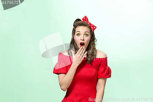 Image of Beautiful young woman with pinup make-up and hairstyle. Studio shot on white background