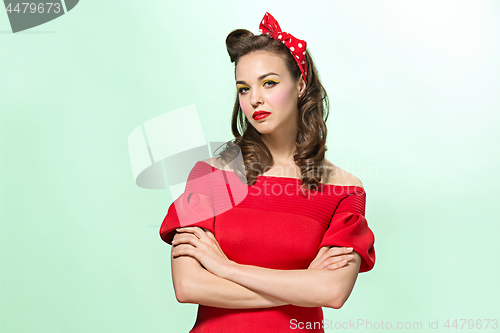 Image of Beautiful young woman with pinup make-up and hairstyle. Studio shot on white background