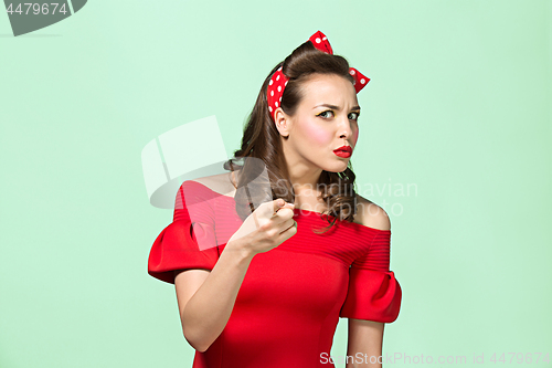 Image of Beautiful young woman with pinup make-up and hairstyle. Studio shot on white background