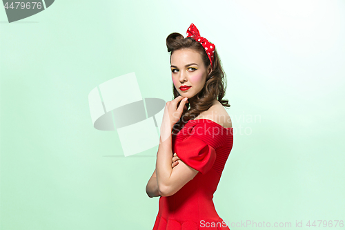 Image of Beautiful young woman with pinup make-up and hairstyle. Studio shot on white background